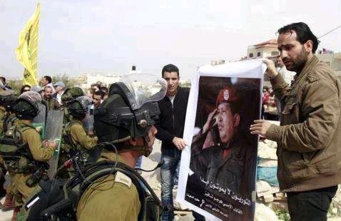 Mars 2013. Des citoyens palestiniens déploient un portrait de Hugo Chavez face aux troupes d'occupation du gouvernement israélien.