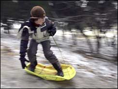 Slip slidin' away: Matt Smith rides down a hill in Dallas, Jan. 17, 2007, after school was canceled.